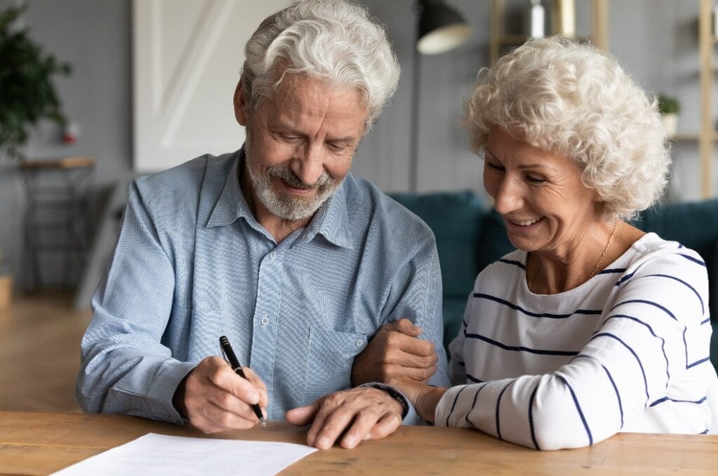 60s elderly spouses at lawyer office sign marriage contract